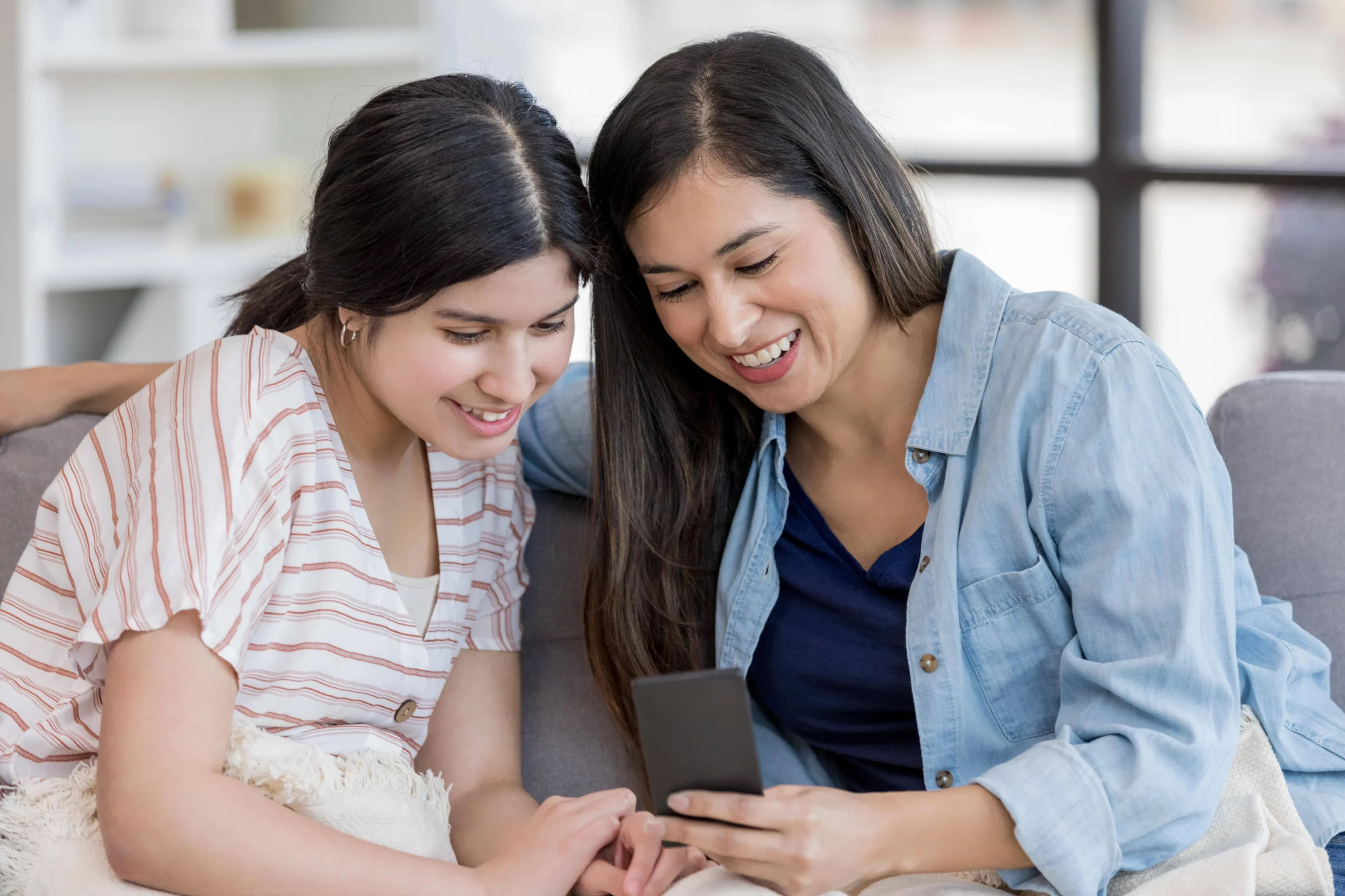 Two women looking at their mobile phone